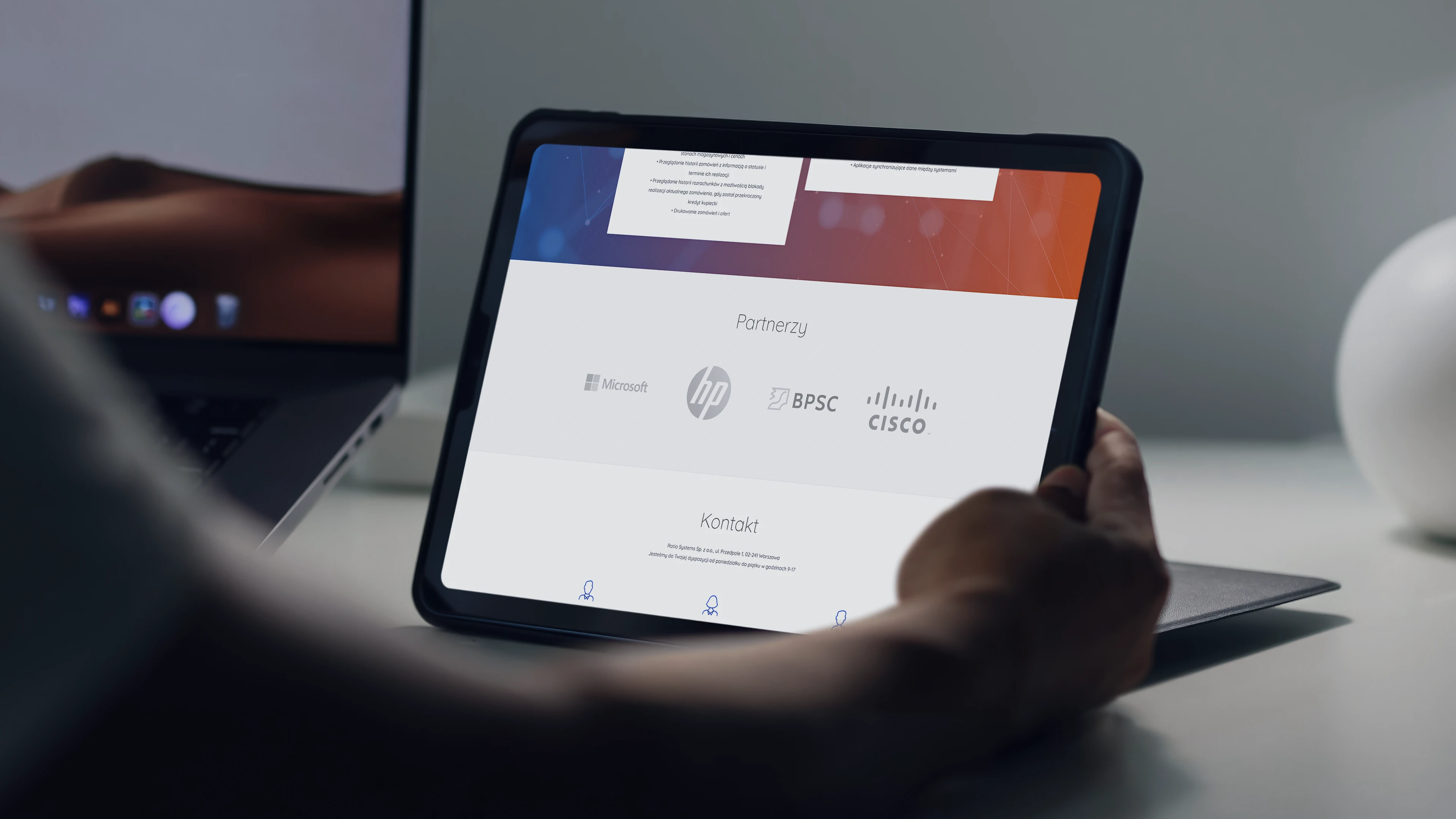 Projekt responsywnej strony Ratio Systems – mockup widoku na tablecie z sekcją partnerów i kontaktu