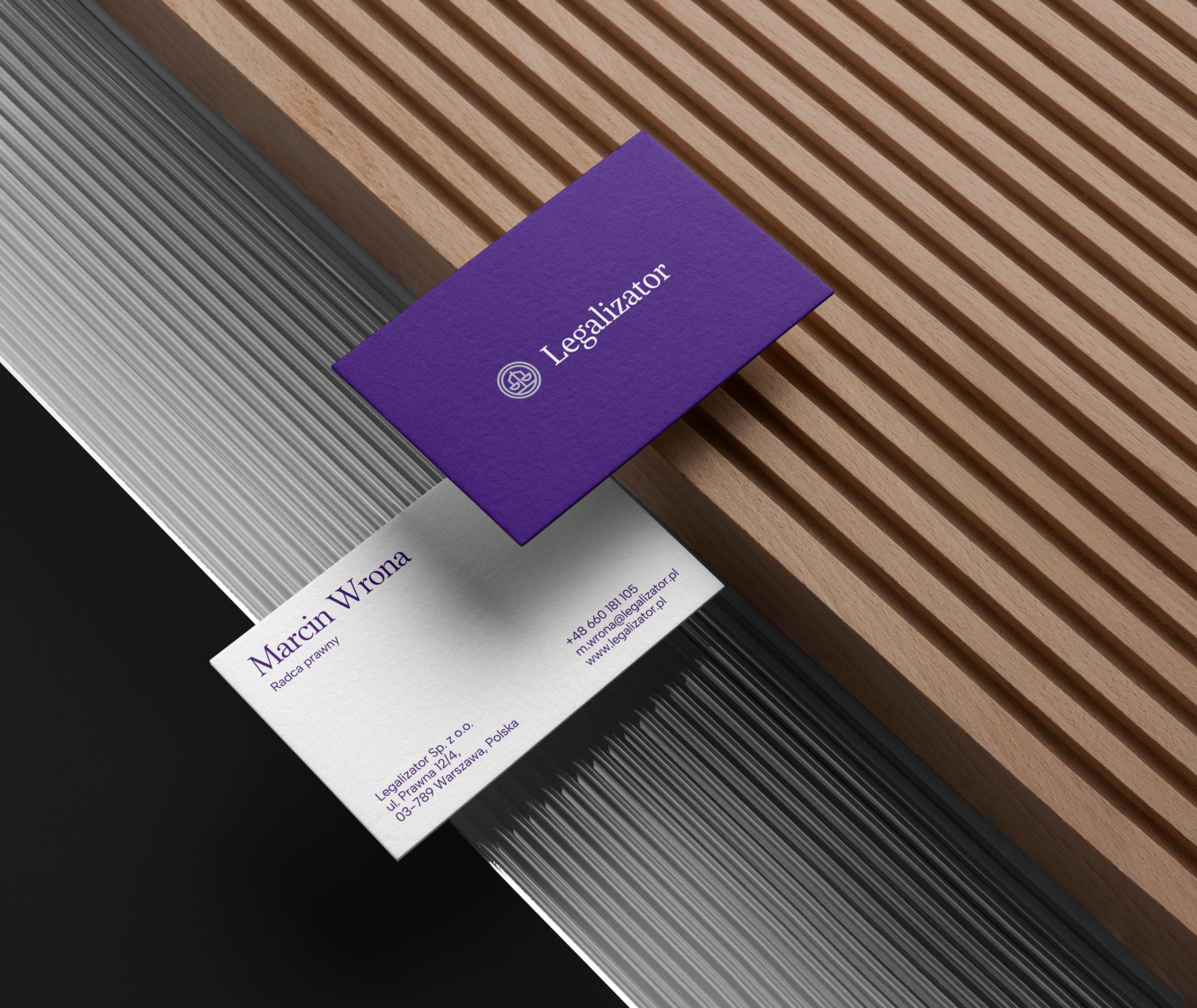 Wizytówki marki Legalizator w fioletowo-białej kolorystyce, prezentujące dane kontaktowe i logo kancelarii.
