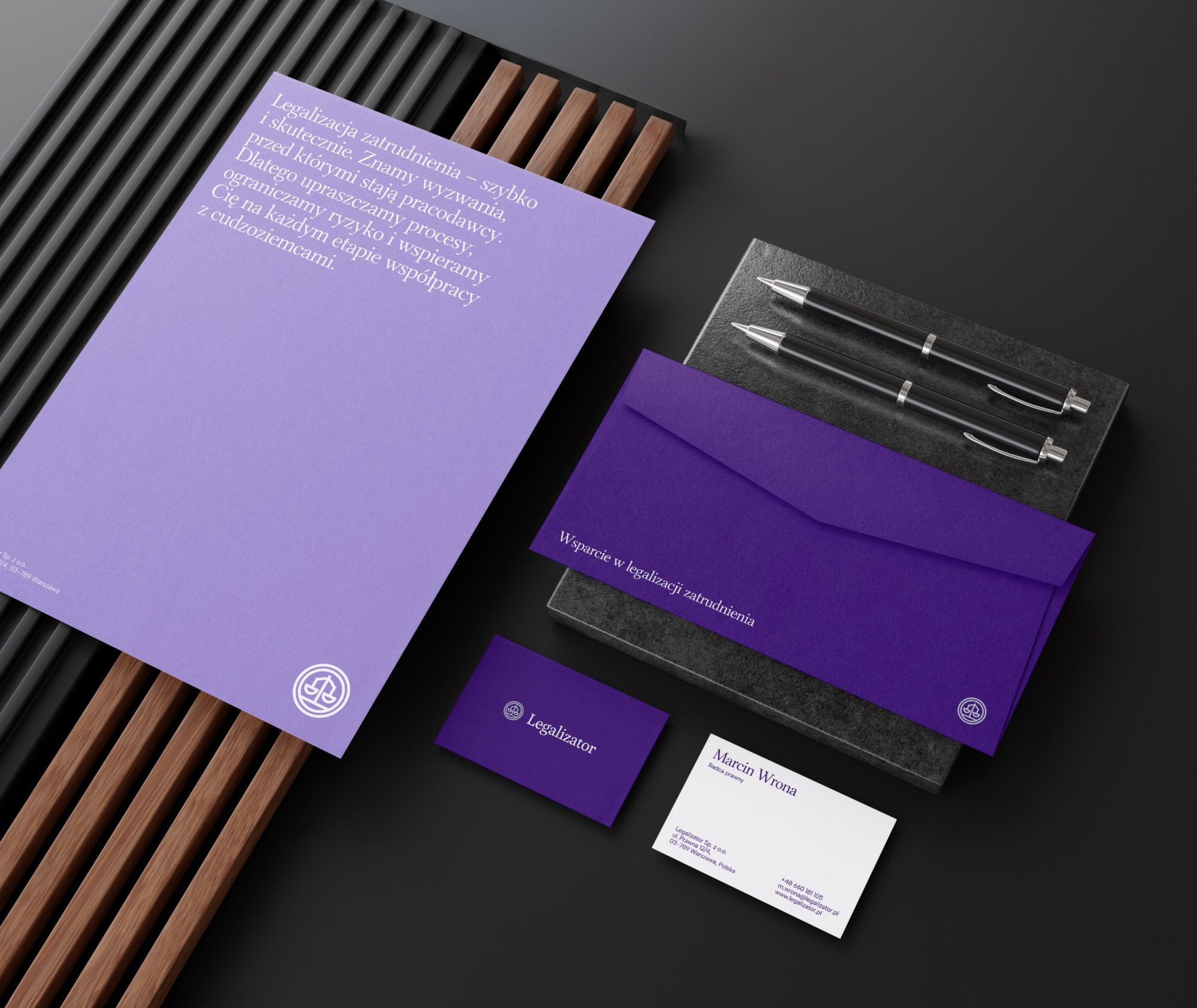 Zestaw papeterii firmowej Legalizator obejmujący teczkę, kopertę, papier firmowy i wizytówki.