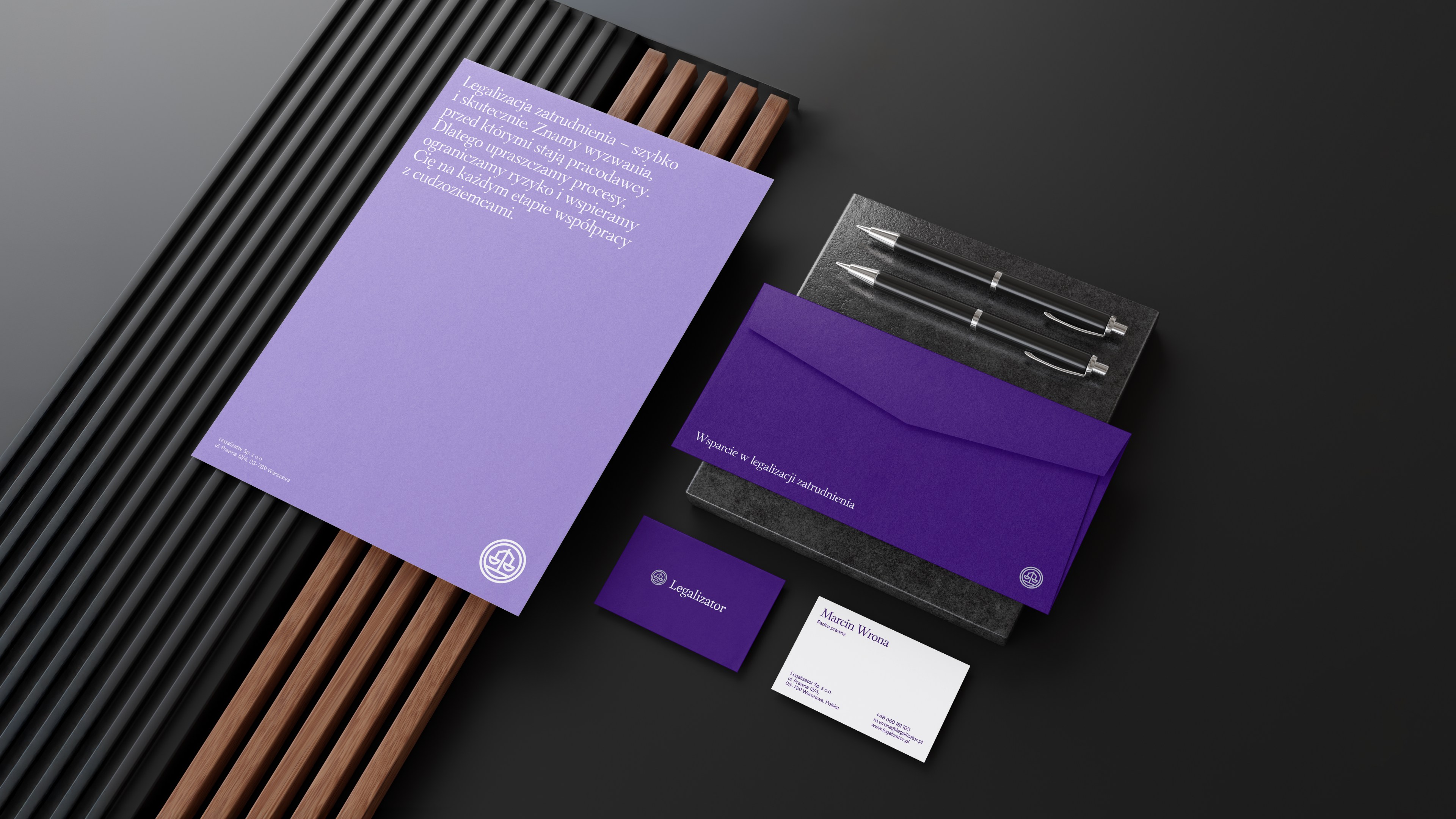 Zestaw papeterii firmowej Legalizator obejmujący teczkę, kopertę, papier firmowy i wizytówki.