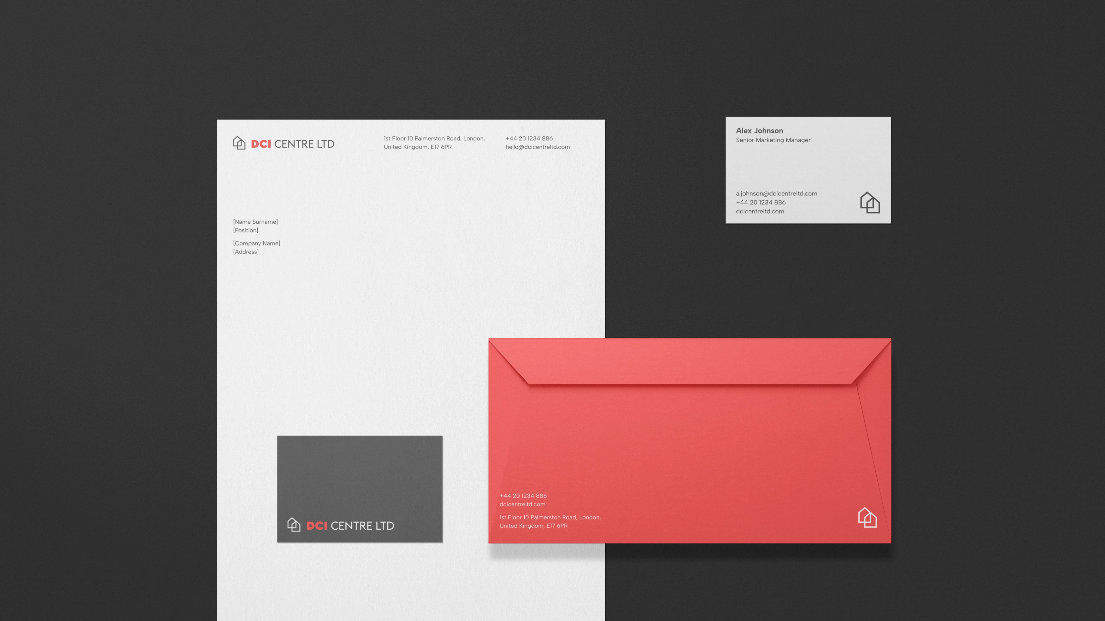 Zestaw papeterii firmowej DCI Centre obejmujący papier, kopertę i wizytówki.