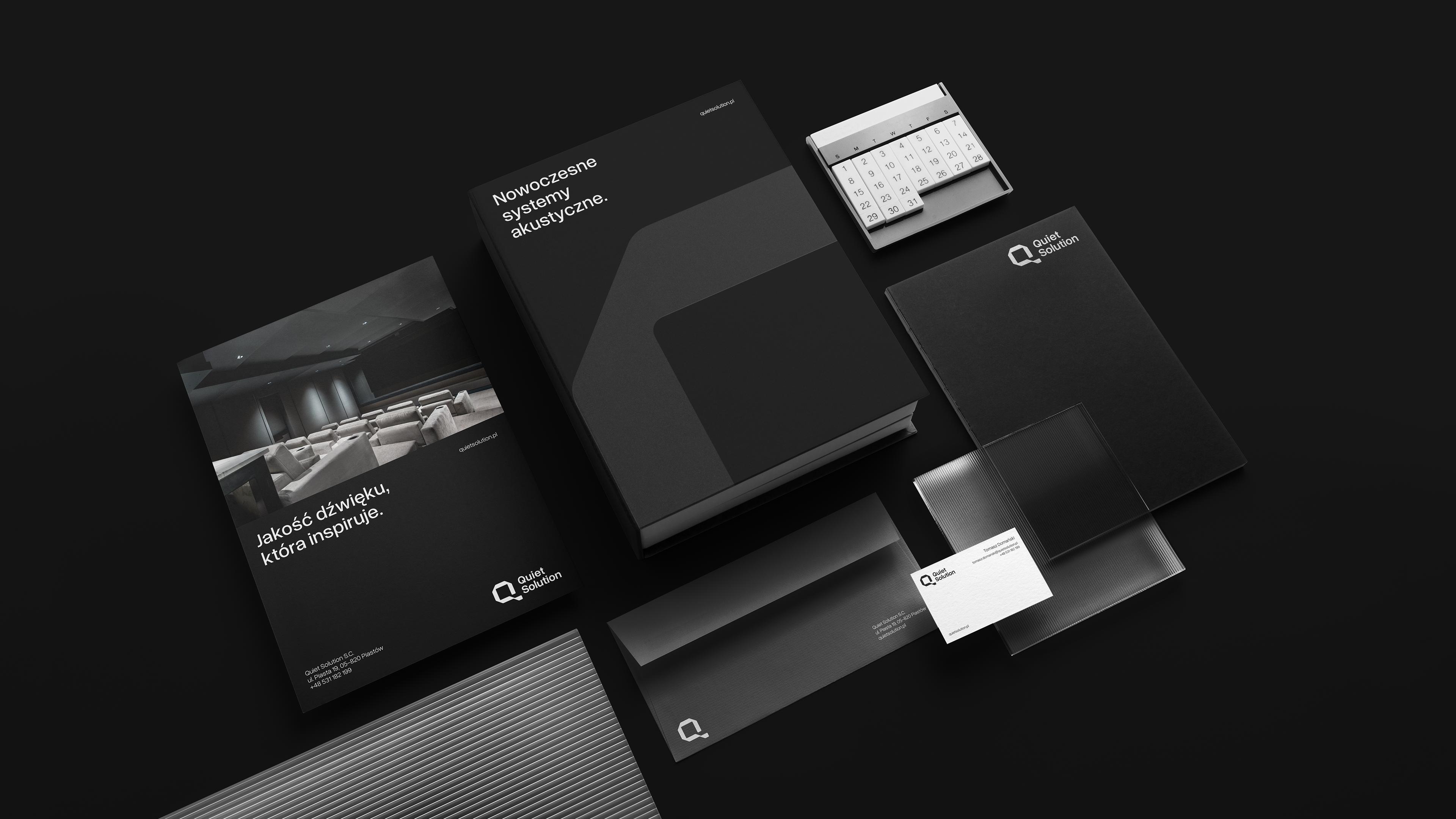 Zestaw materiałów firmowych Quiet Solution obejmujący katalog, wizytówki i elementy identyfikacji.